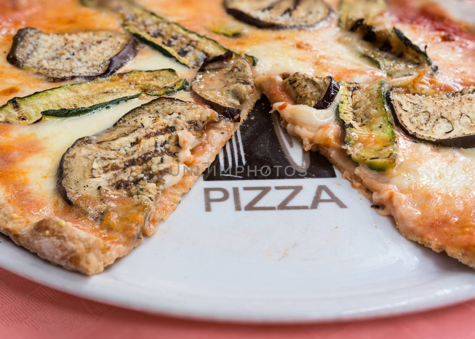 In the picture a whole wheat pizza with eggplant , zucchini , tomato and Neapolitan buffalo mozzarella.( Bufala campana)