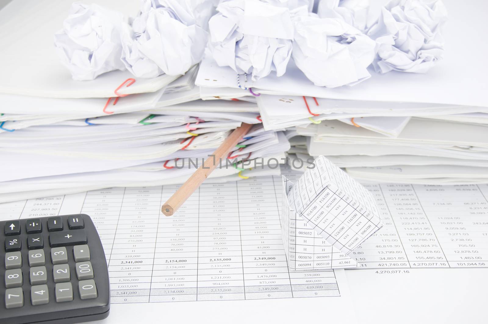 Bankruptcy of house and calculator on finance account have bottom of pencil with group of paper ball on stack of paperwork as background.