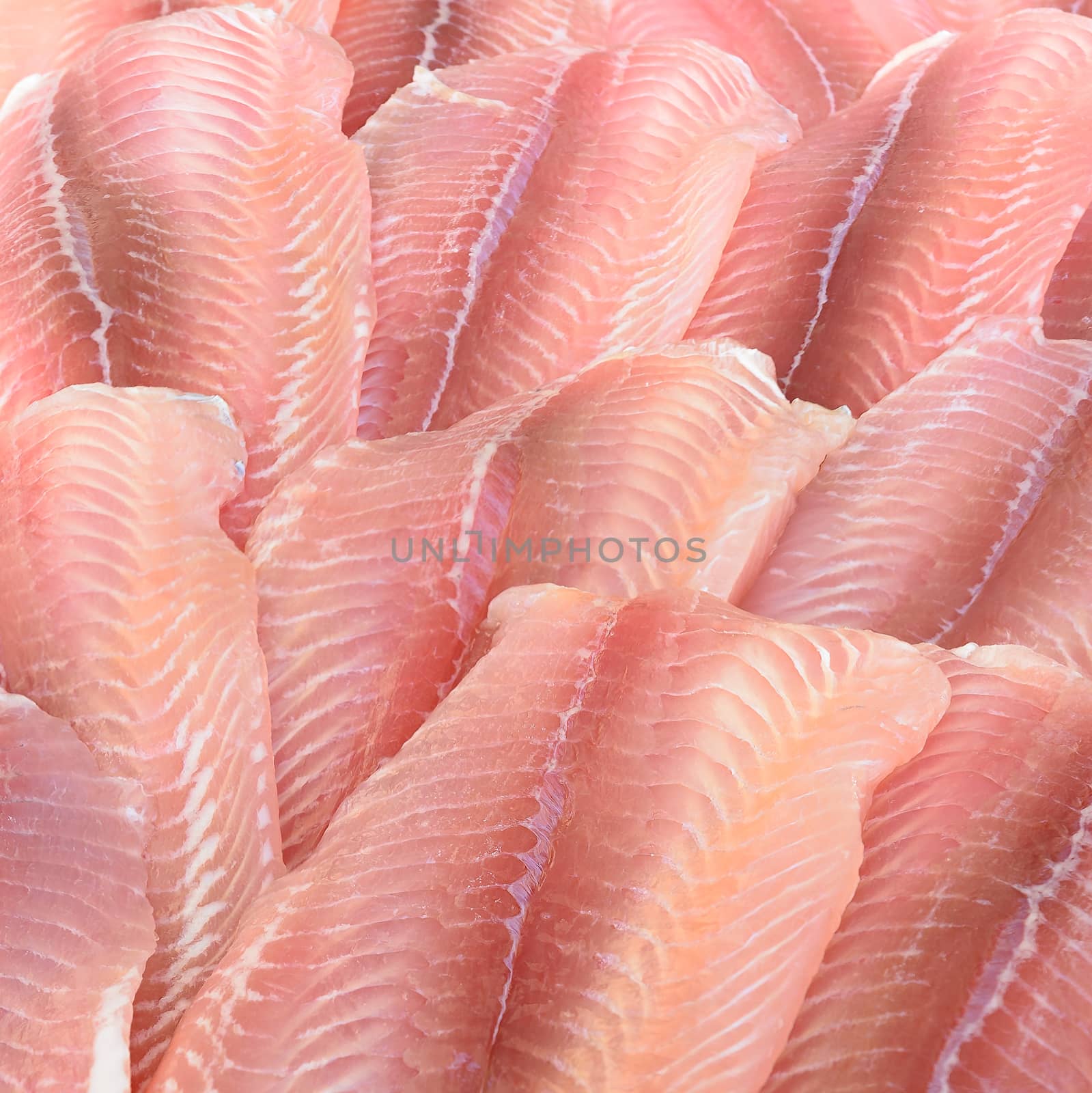 In the picture a group of pangasius fillets arranged in a row and pattern