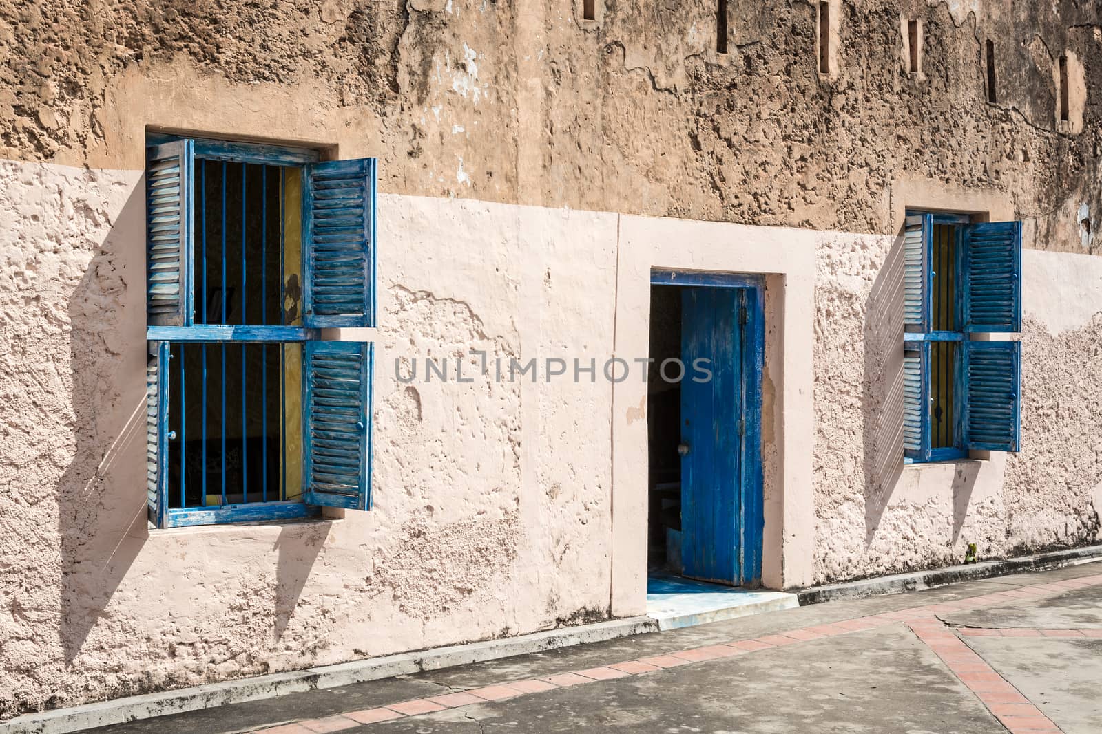 In the pictured two blue windows and a blue door , they contrast with the wall of the house .