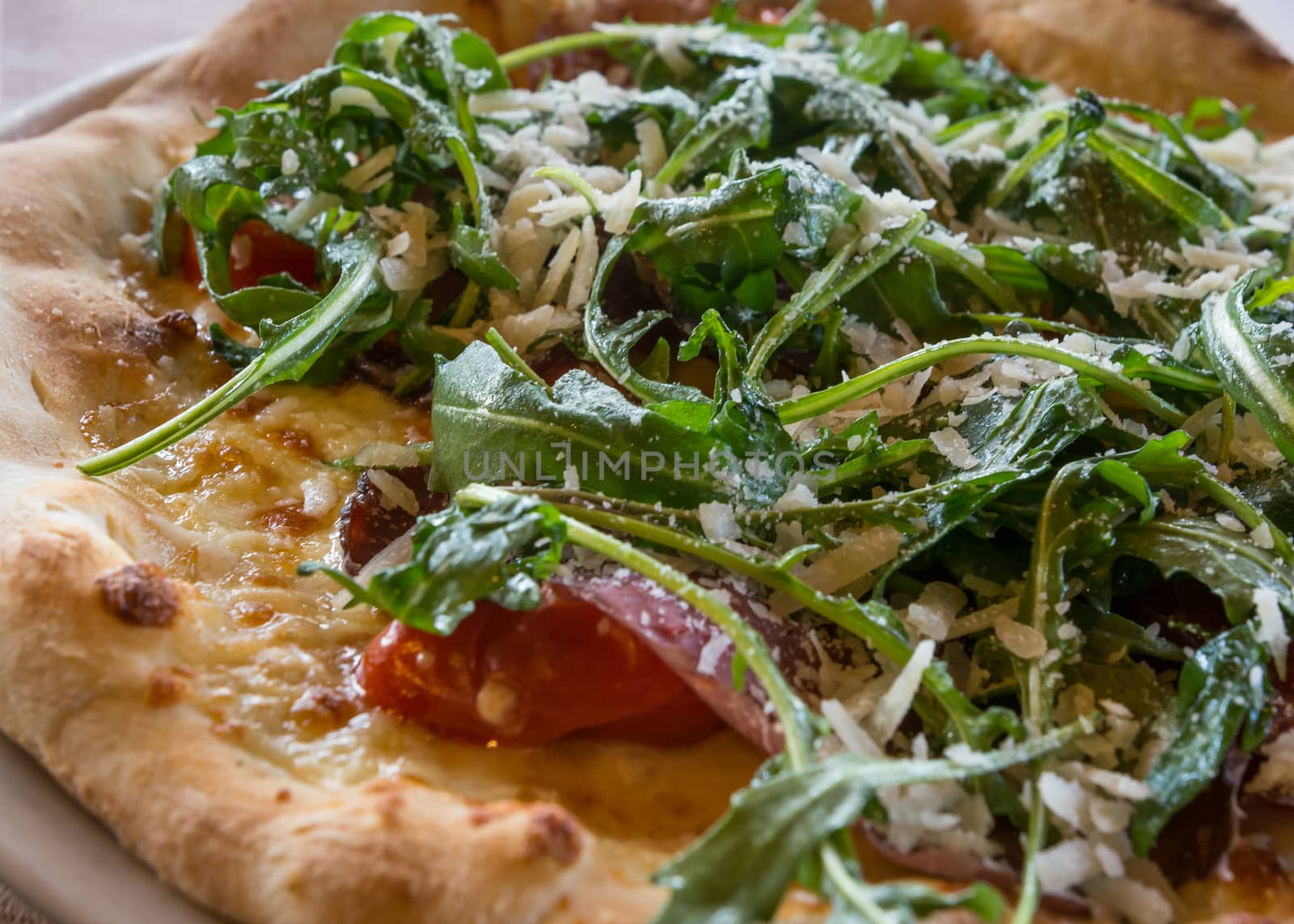 Italian pizza Valtellinese with parmesan cheese,tomato, tomato cherry,mozzarella,arugula.