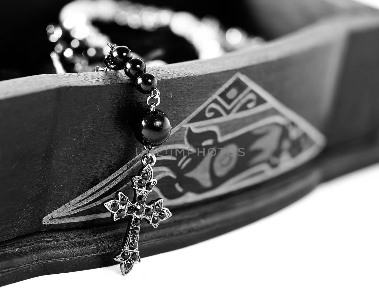 A rosary coming out of a carved box in wood.