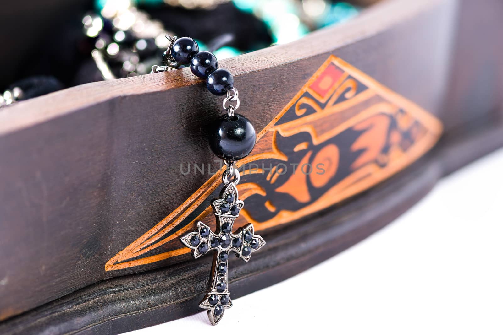 A rosary coming out of a carved box in wood