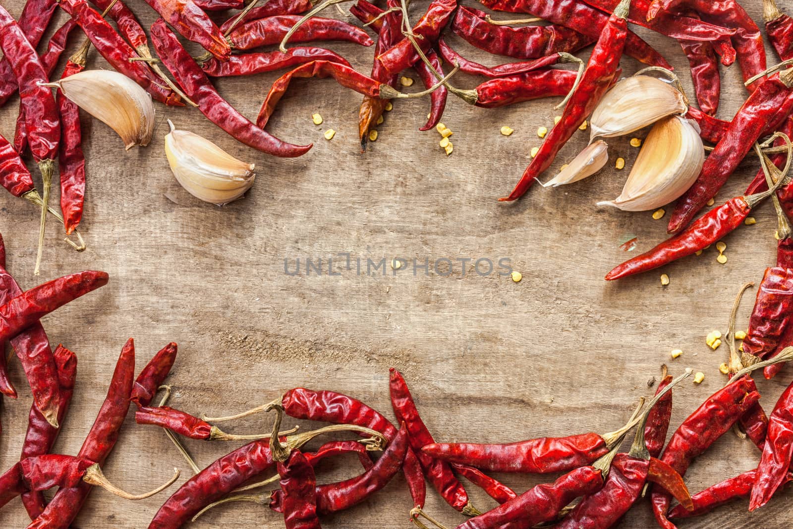 Dried red chili pepper and fresh garlic isolated on wooden background .