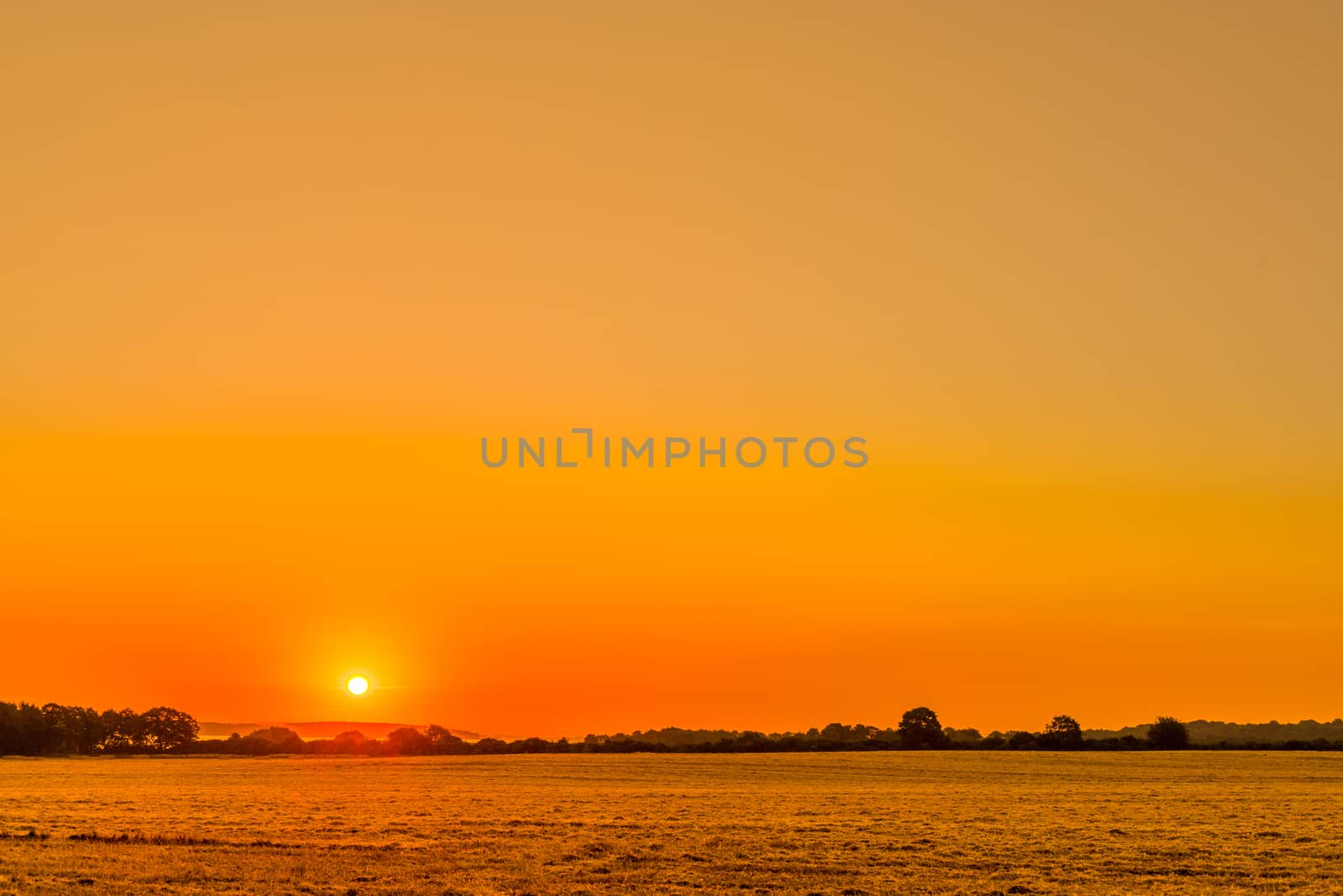 Countryside landscape with a beautiful sunrise in orange colors
