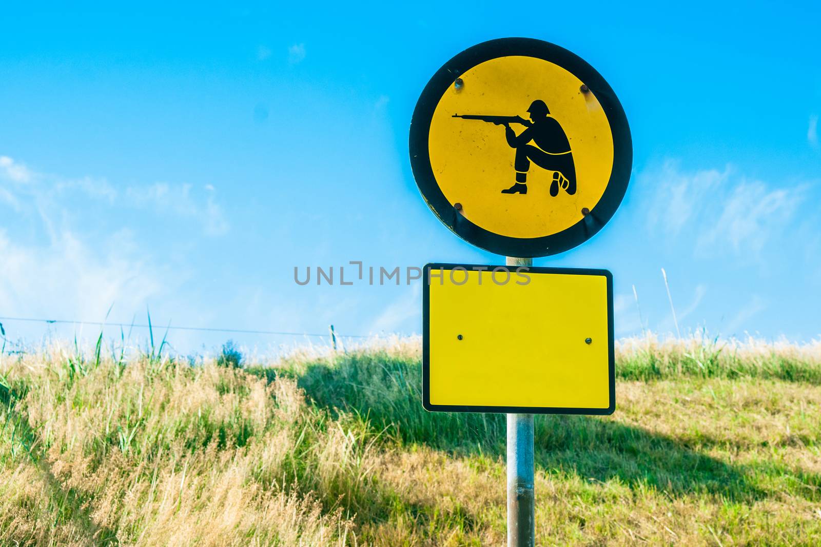 Shooting range sign in yellow color on a field