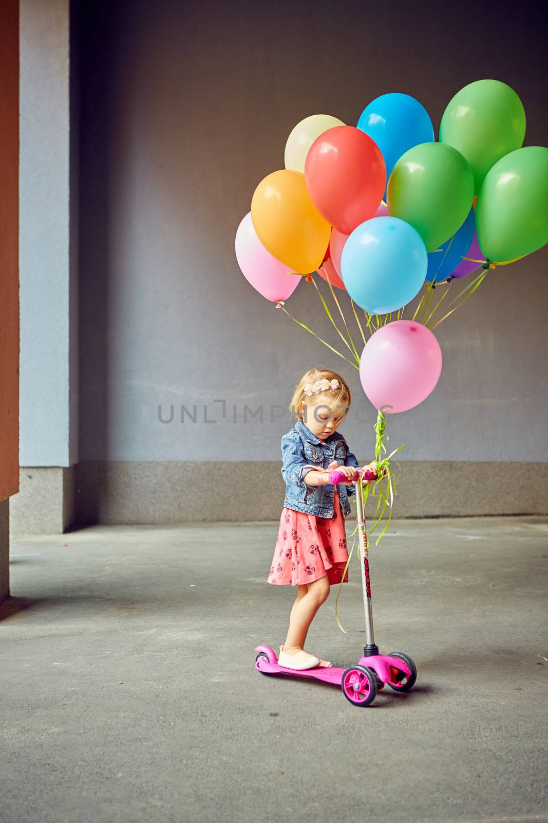 happy little girl outdoors with balloons by sarymsakov