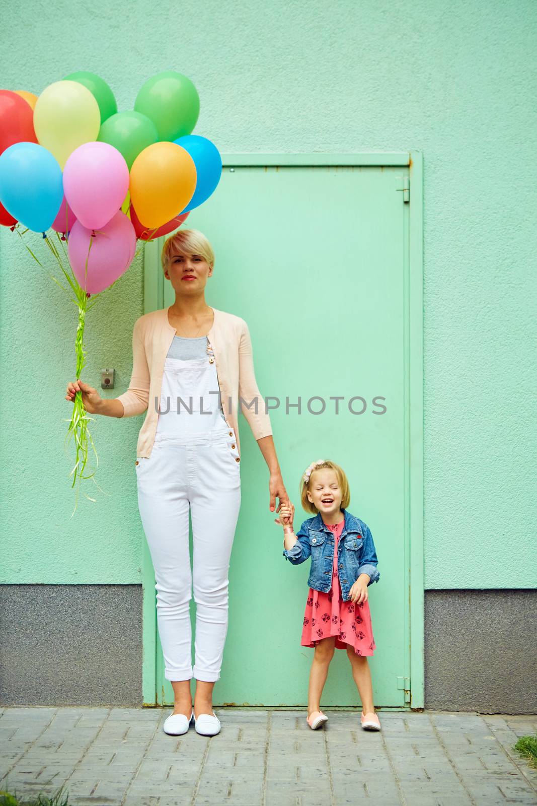 mother and child with colorful balloons mother and child with colorful balloons on green background