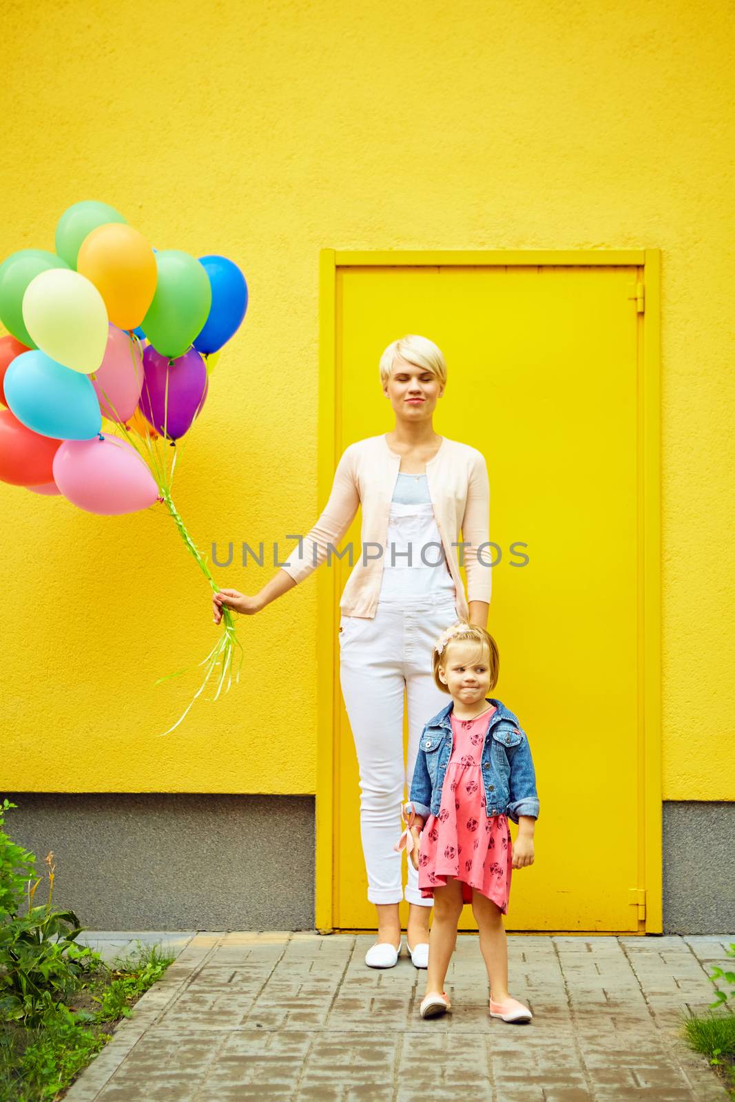 mother and child with colorful balloons on a yellow background