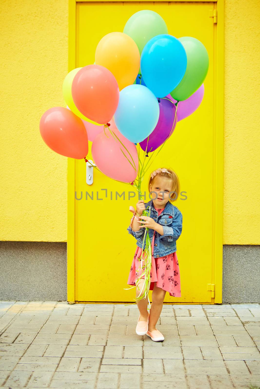happy little girl outdoors with balloons by sarymsakov