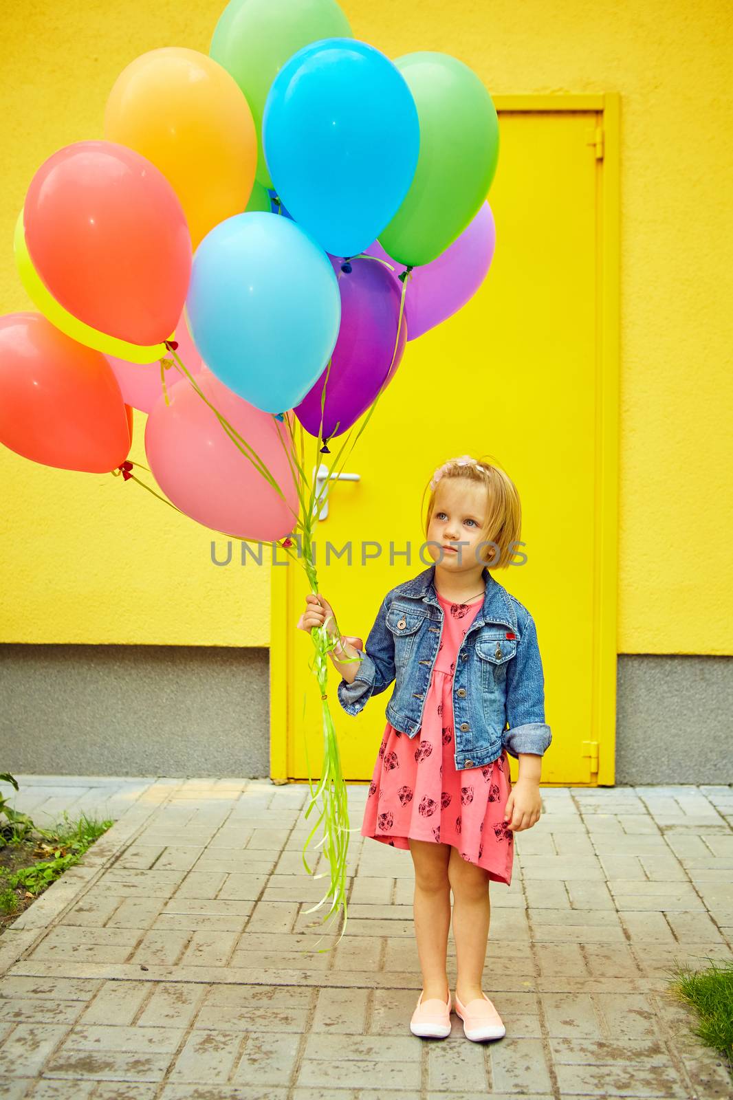 inspiration, happy little girl outdoors with balloons on a yellow background