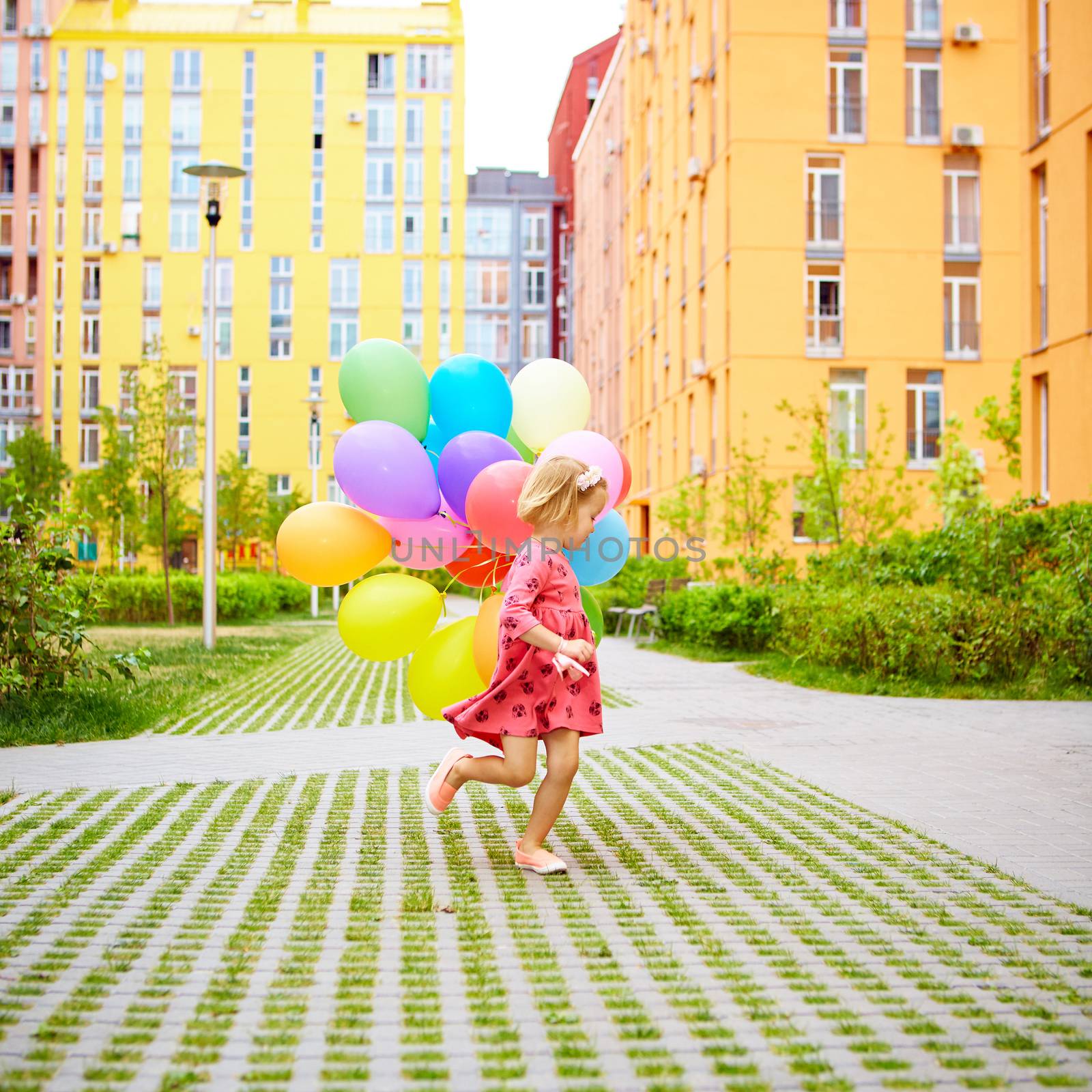 happy little girl outdoors with balloons by sarymsakov