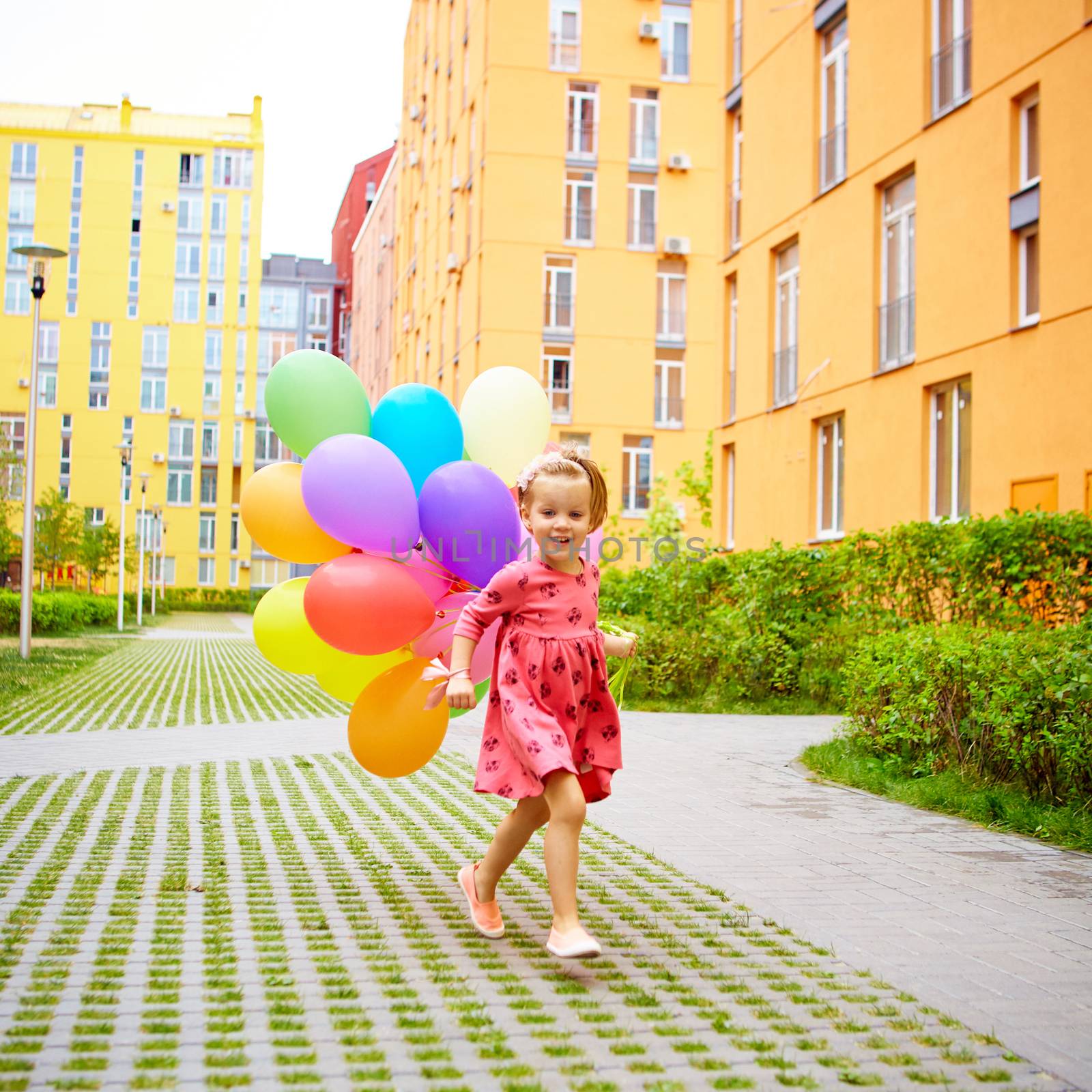 happy little girl outdoors with balloons by sarymsakov