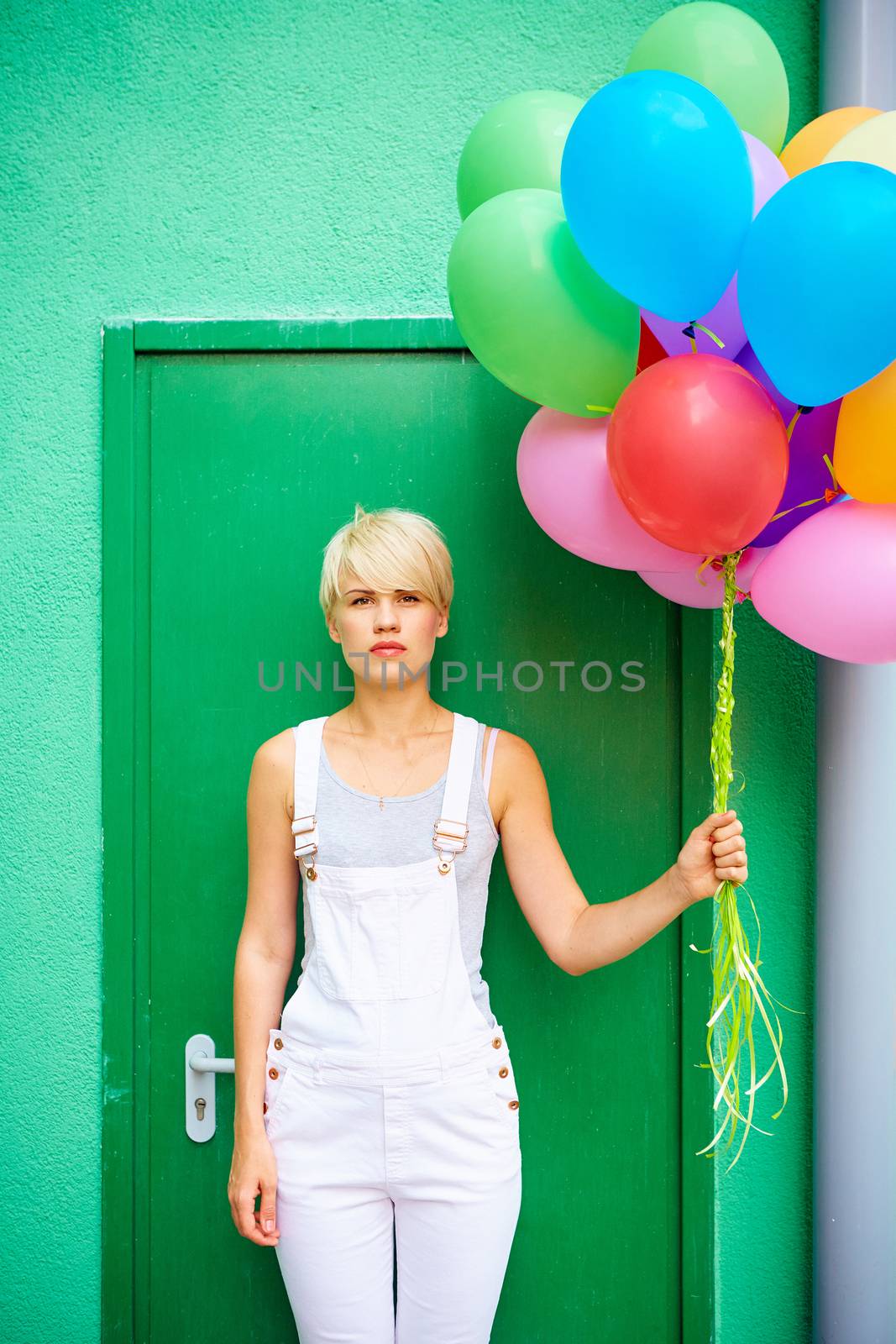 Happy young woman with colorful latex balloons by sarymsakov
