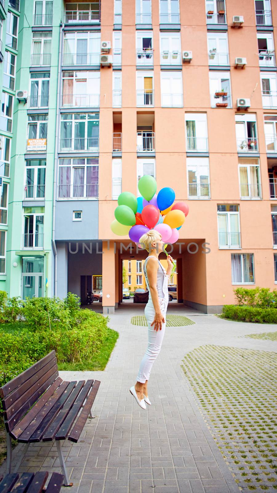 Happy young woman with colorful latex balloons by sarymsakov