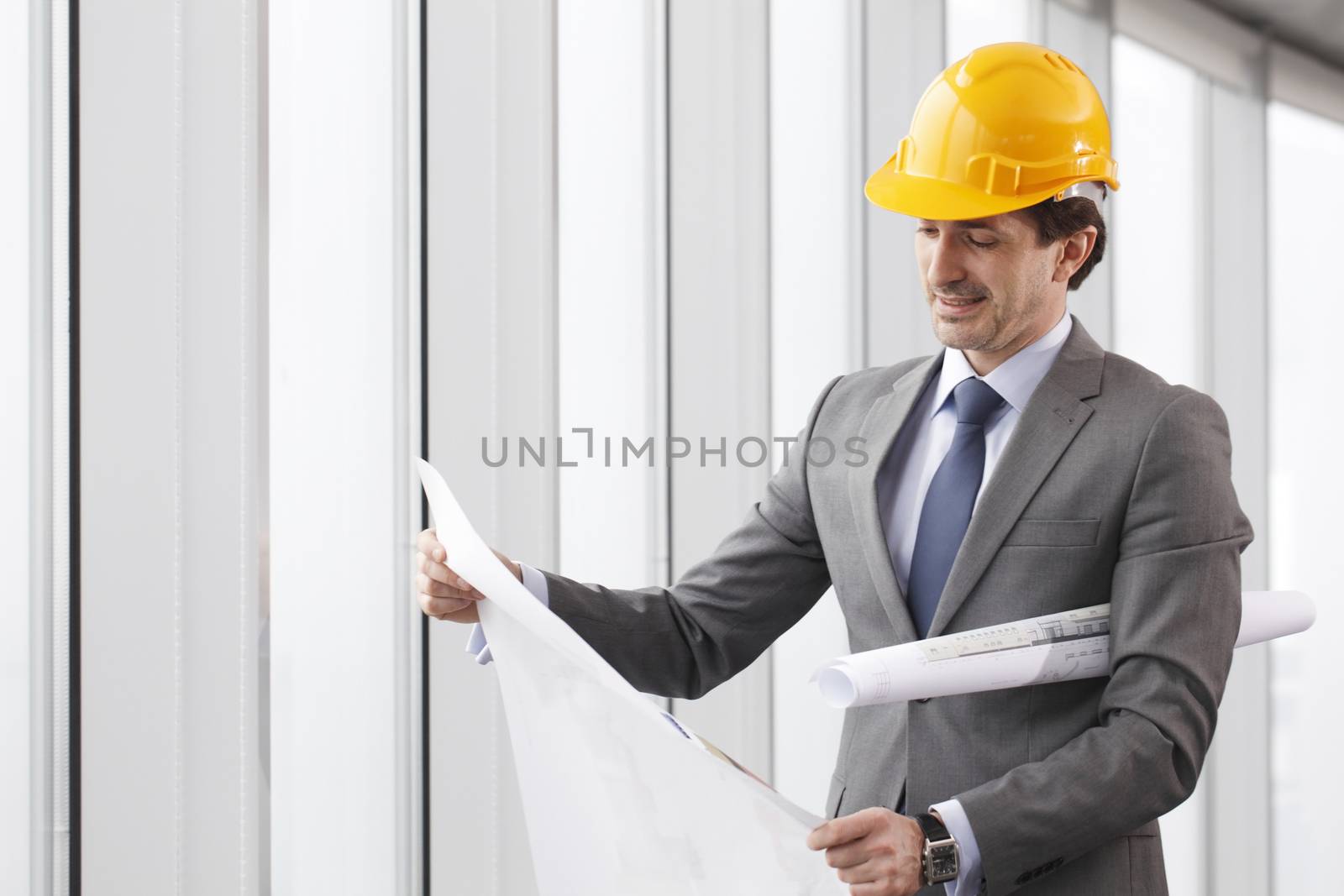 Architector in hardhat and business suit with construction plans