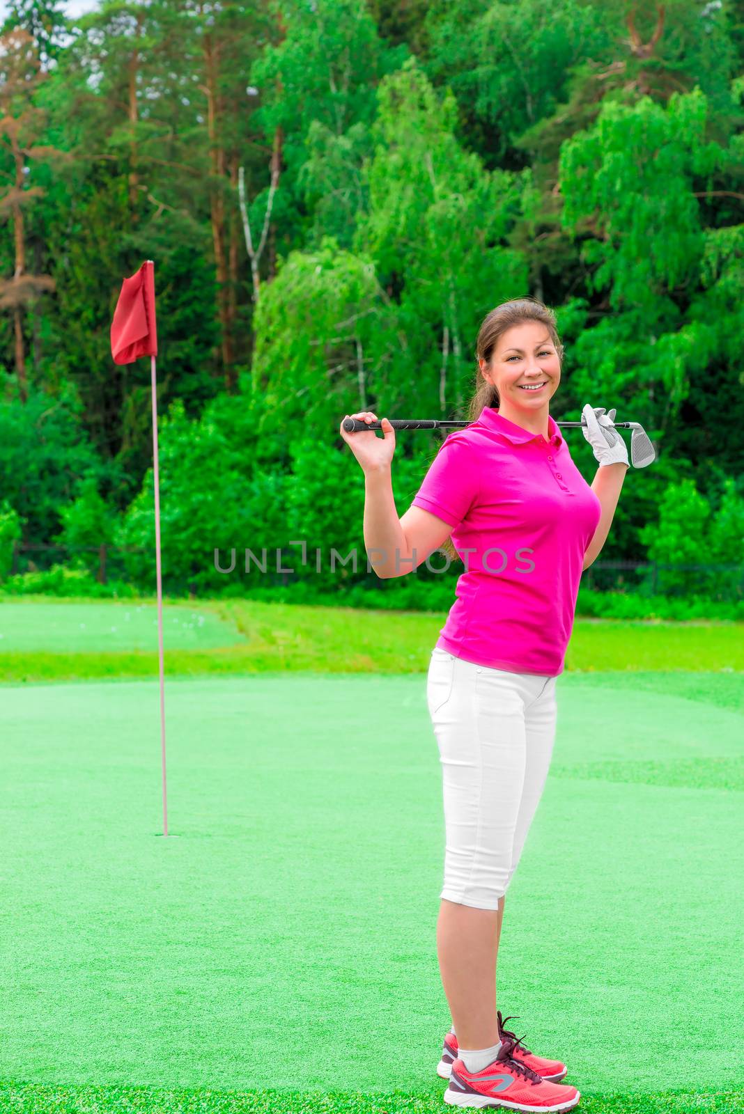 young beautiful girl on a golf course with a golf club