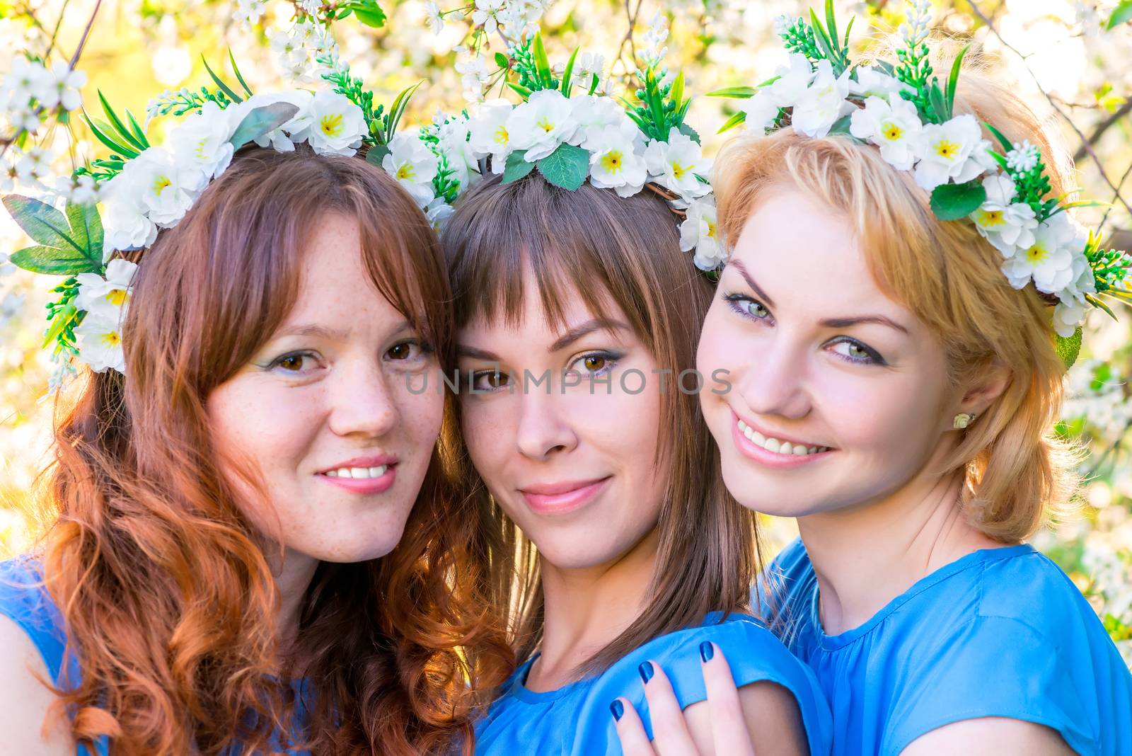 Three girls 30 years with wreaths on the head in the flowered ga by kosmsos111