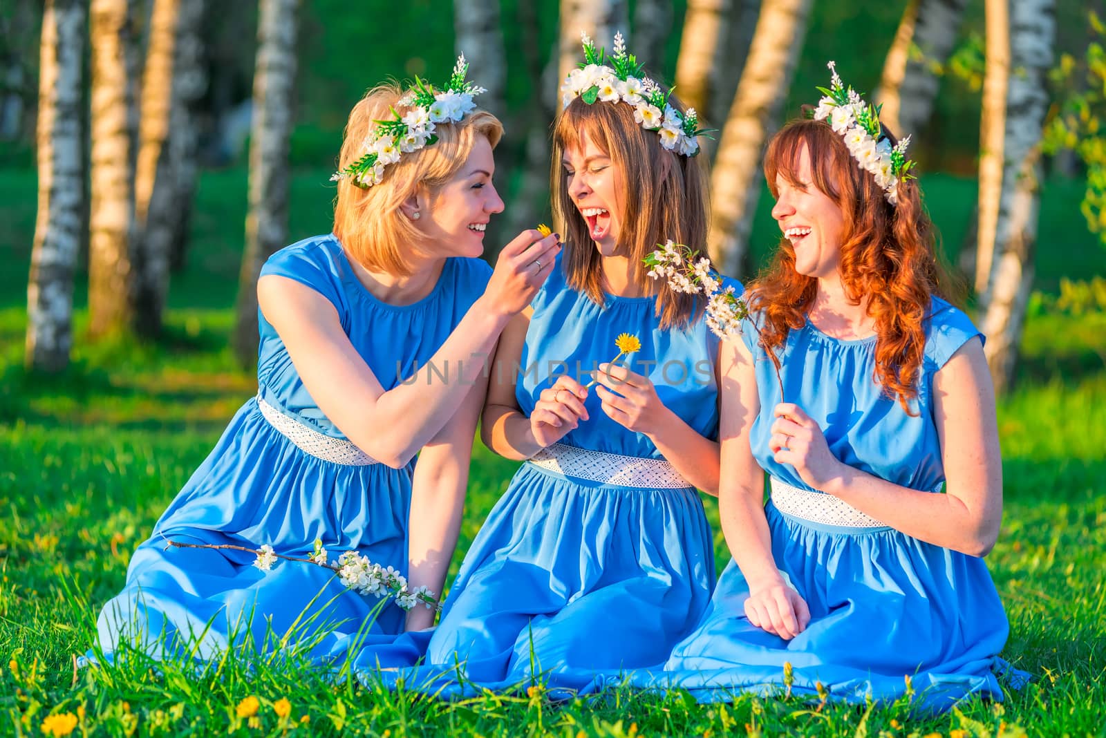 Three girls on the lawn in equally clothes having fun