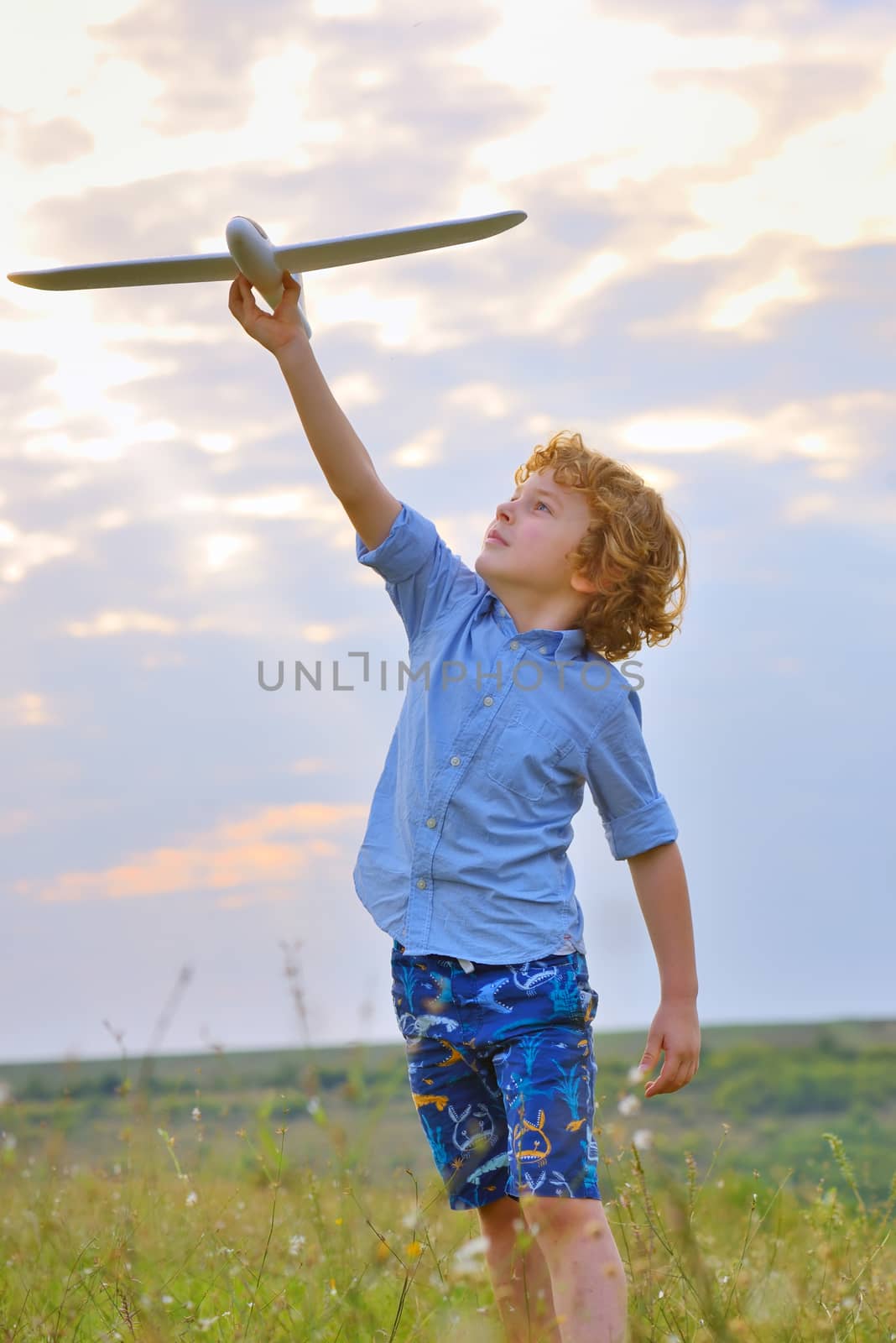 boy throwing airplane in the field