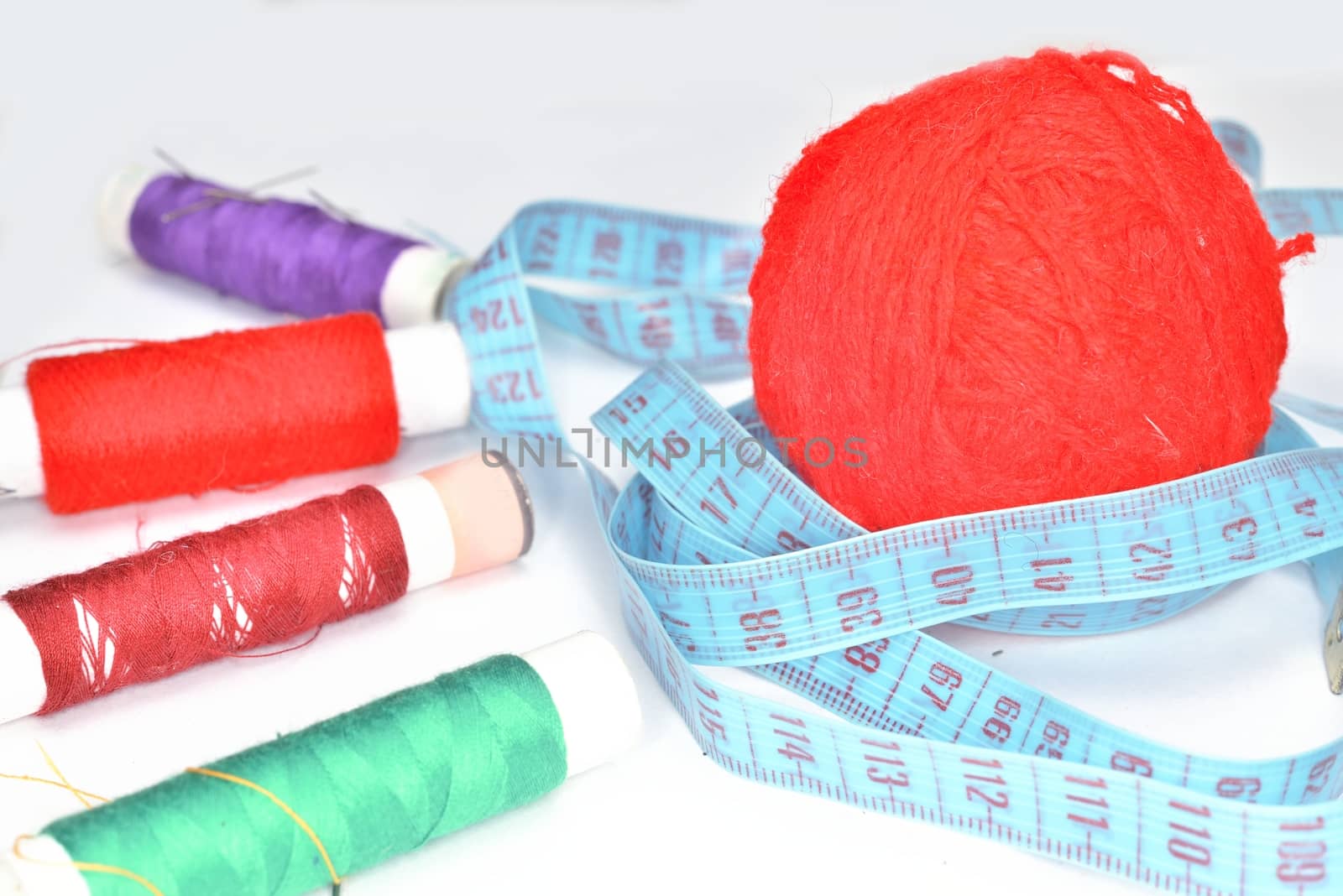 purple yarn, blue  ruler and many colored clew  with needles for sewing