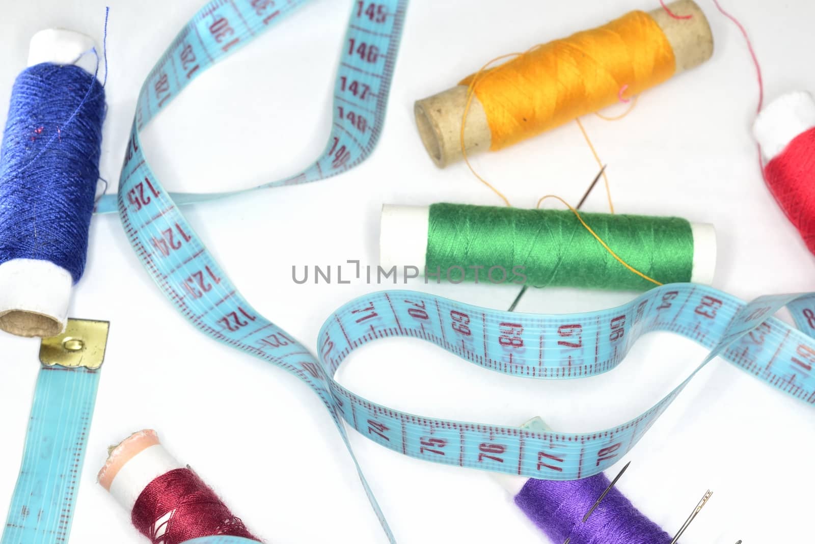 sewing fashion background ( retro blue  ruler and many colored clew  with needles for sewing )