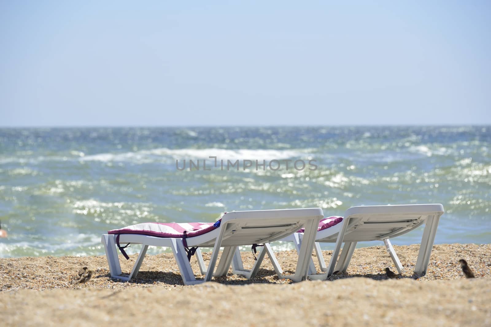 white sunbed near sea on sand ( summer holiday)