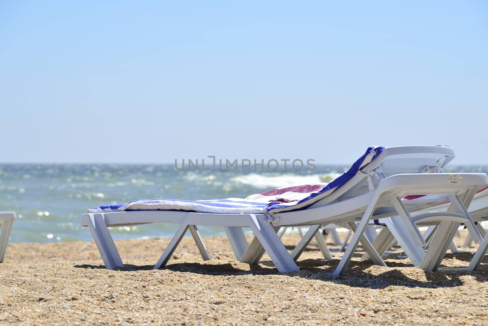 white sunbed near sea on sand ( summer holiday)