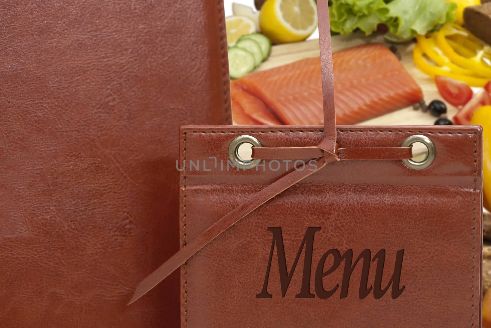 brown leather menu in a restaurant or cafe against the background of vegetables and fish