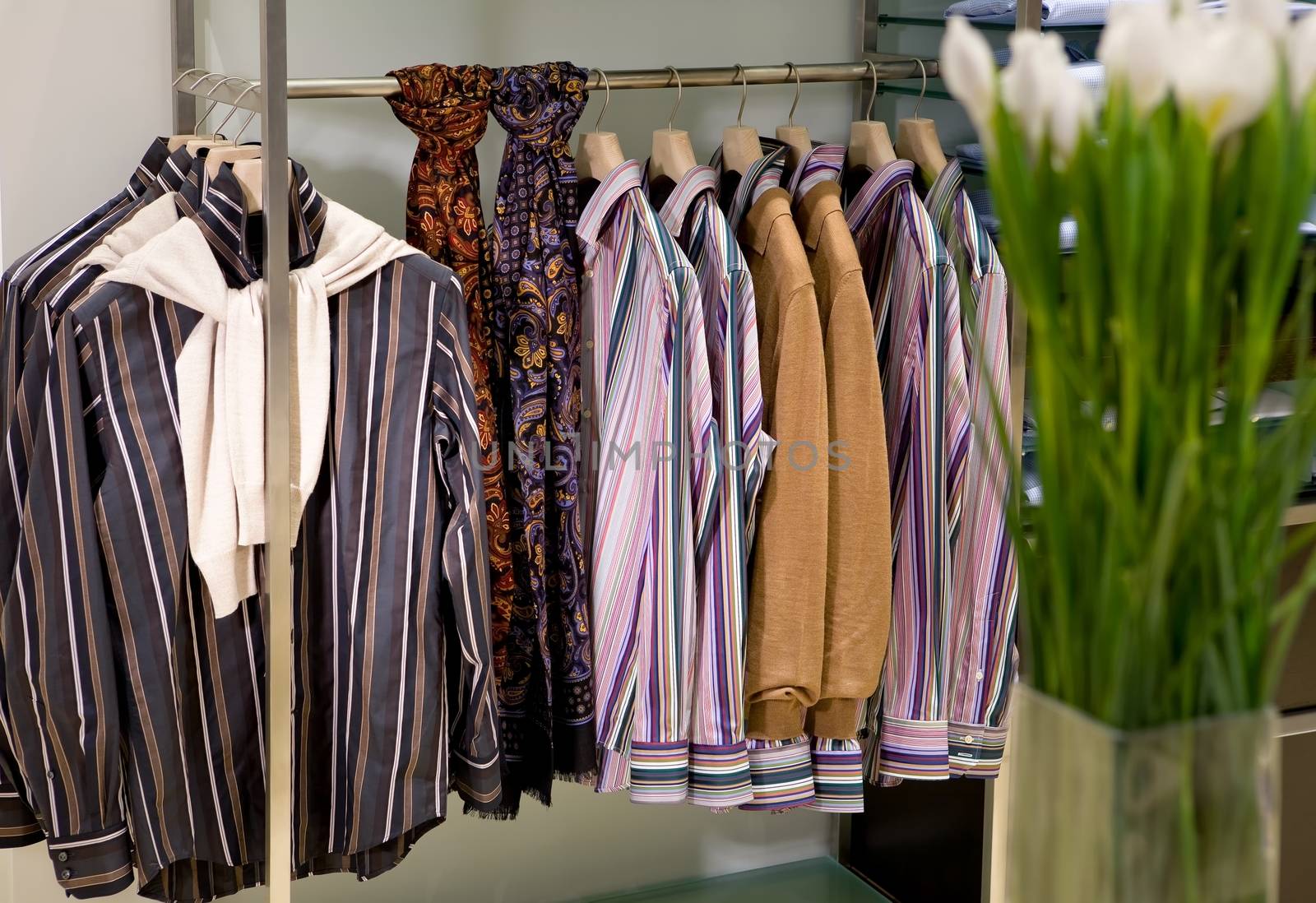 inside fashion store (Men's and women's shirts, blouses and accessories on hangers )