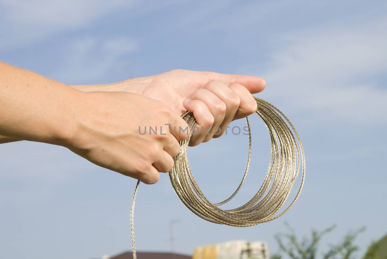 shiny rope in hands on sky backgroung