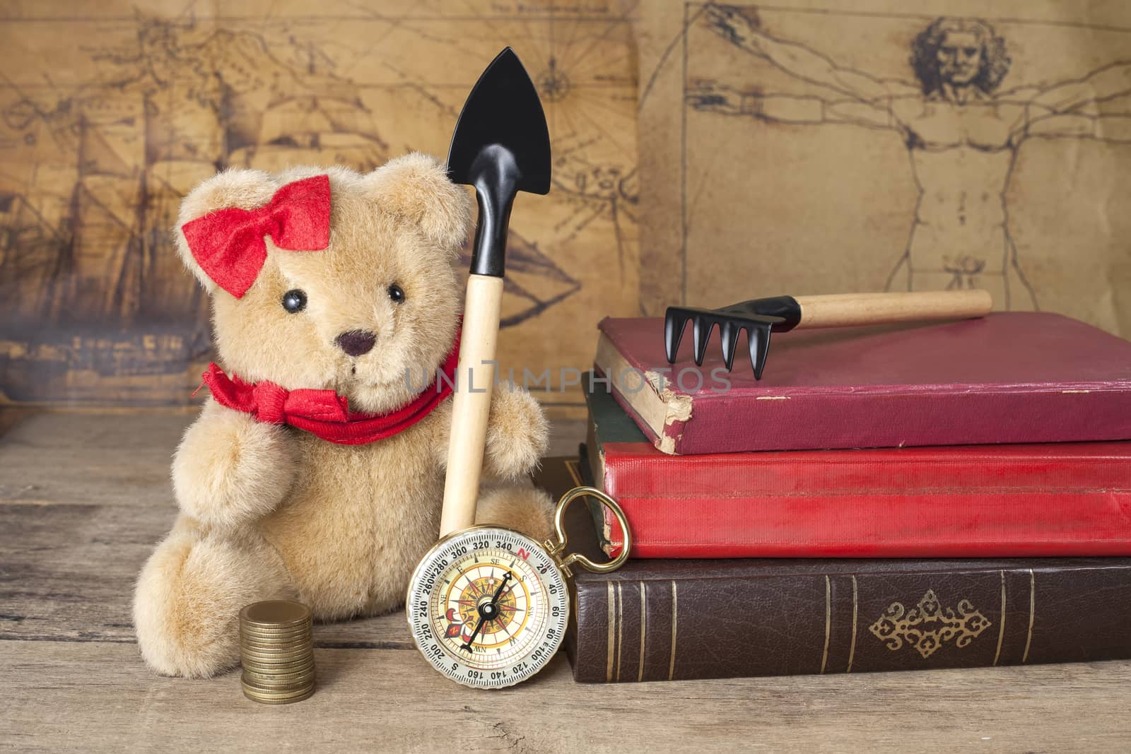 bear toy with shovel old map and compass