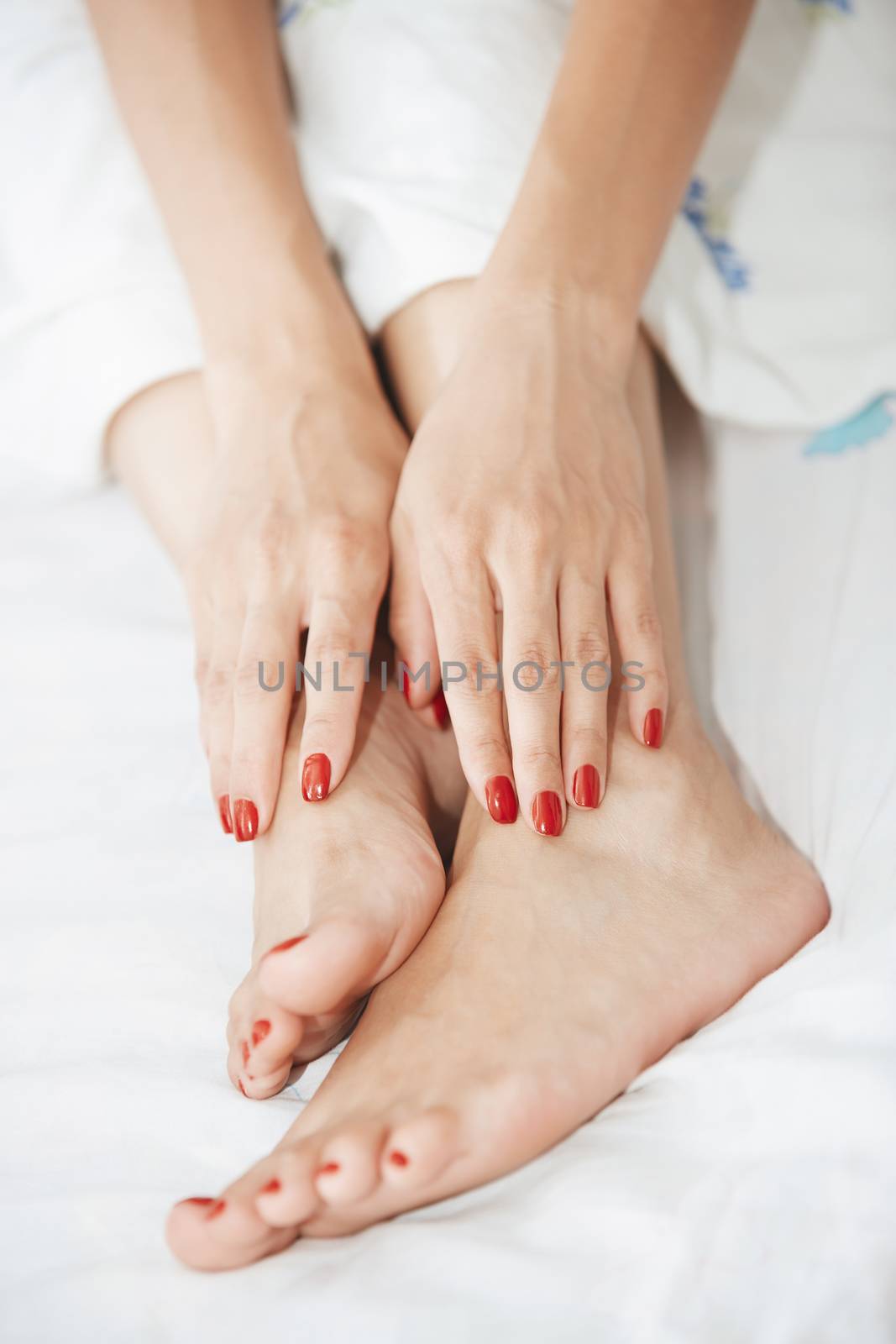 Woman feet and hands with red nail polish