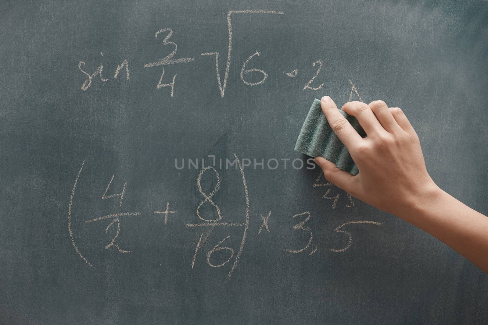 Hand of student studying mathematics and writing on a blackbroard