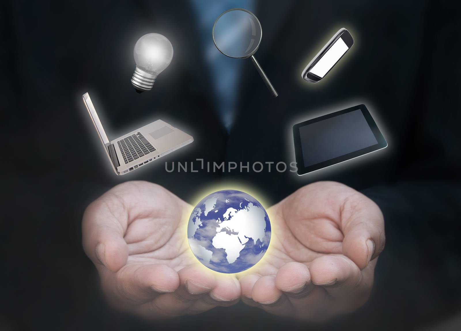 Business man with a laptop, tablet, mobile phone and various work related devices spinning around a globe 