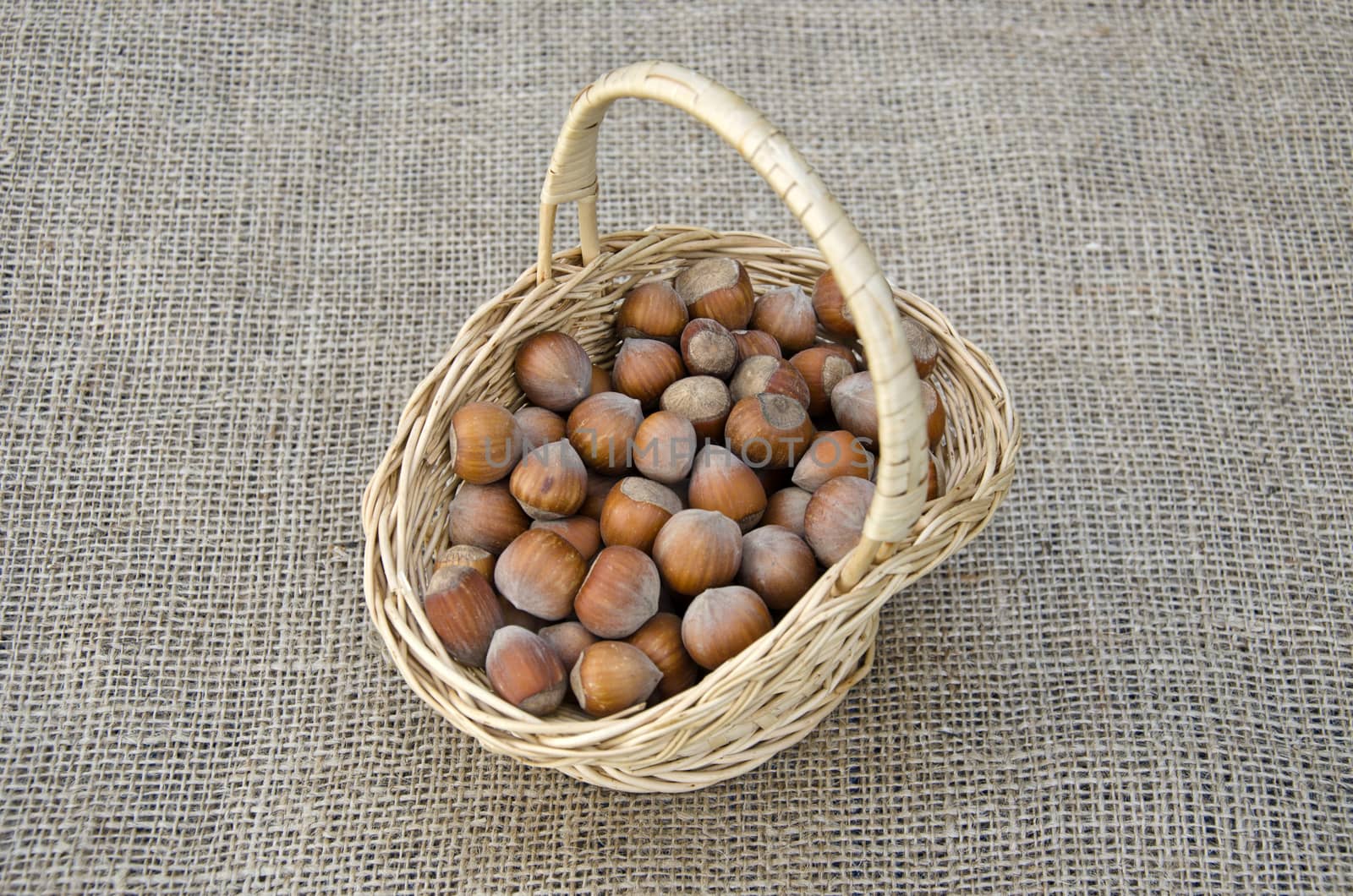 Hazel nuts in wicket basket on linen - healthy food