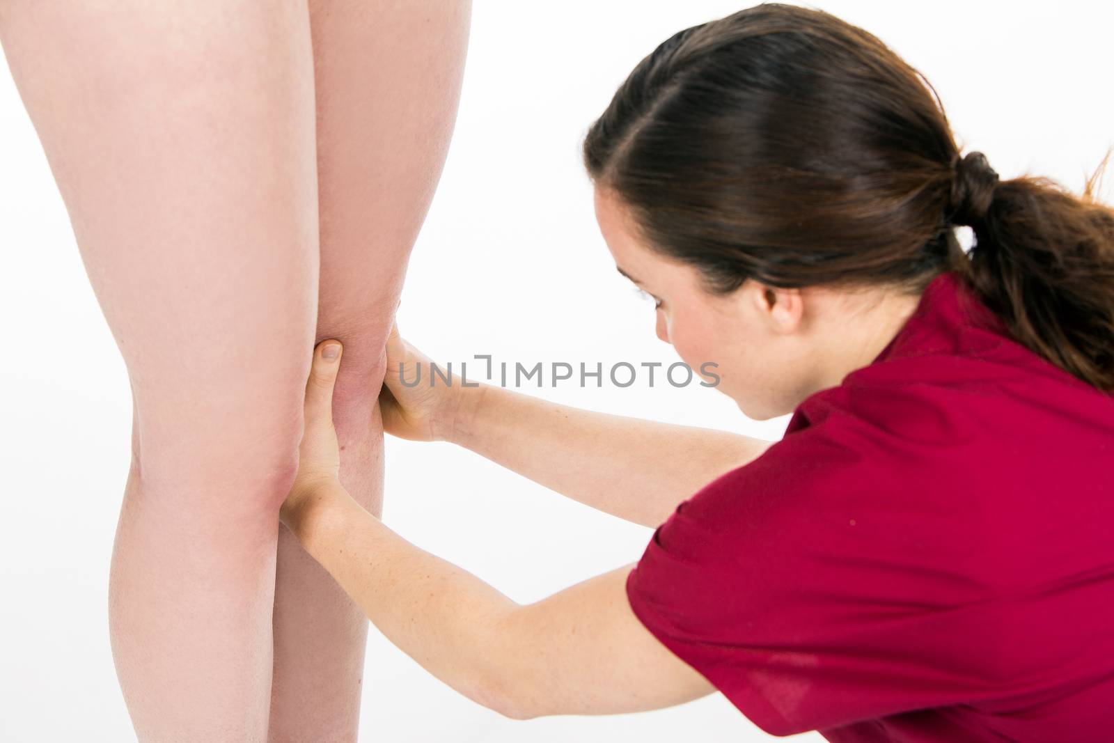 physiotherapist doing knee evaluation by Flareimage