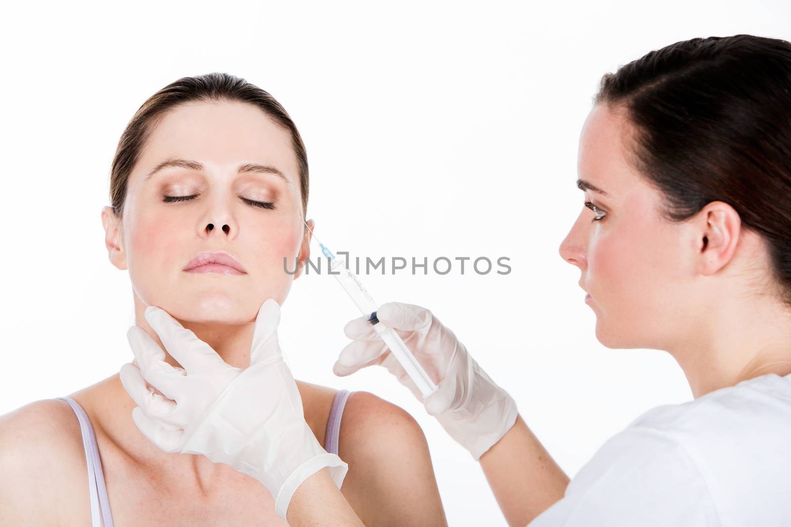 doctor gets botox injection to a woman patient by Flareimage