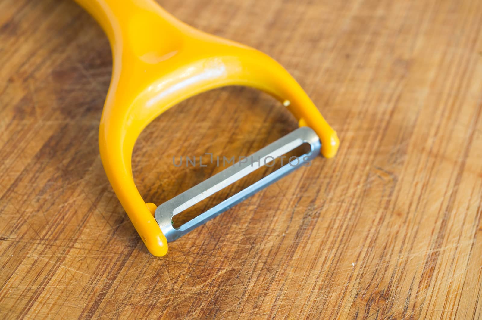 Close up of a sharp peeling knive on wooden background