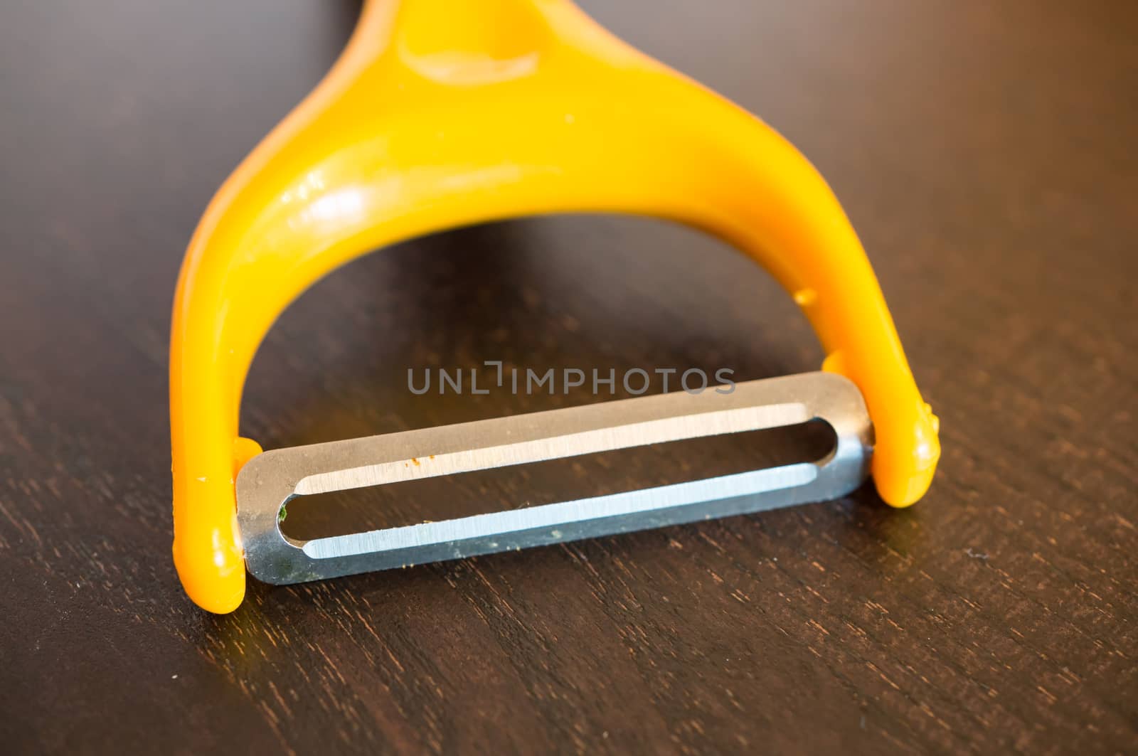 Close up of a sharp peeling knive on wooden background