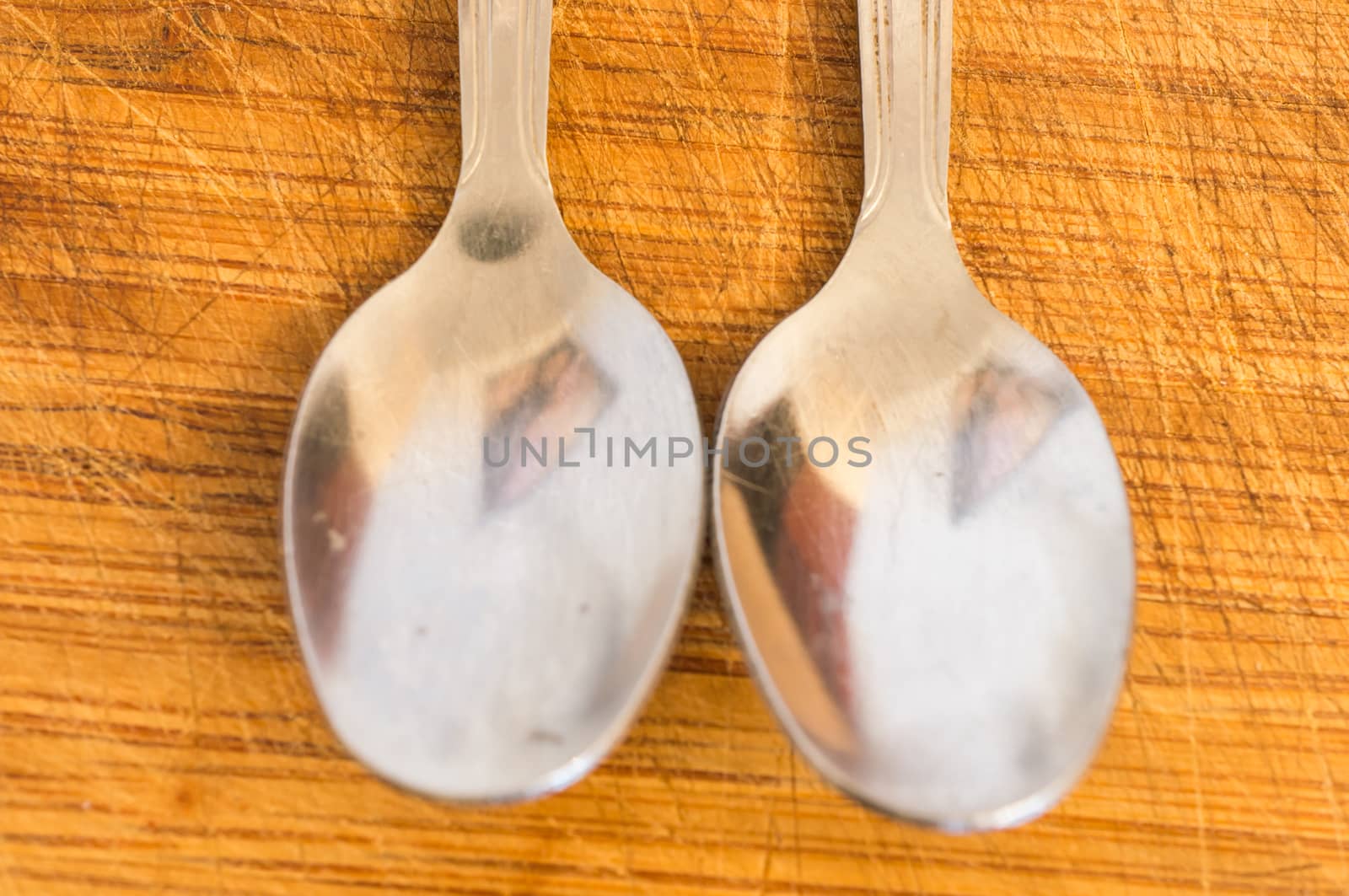 Silver spoons on wooden background