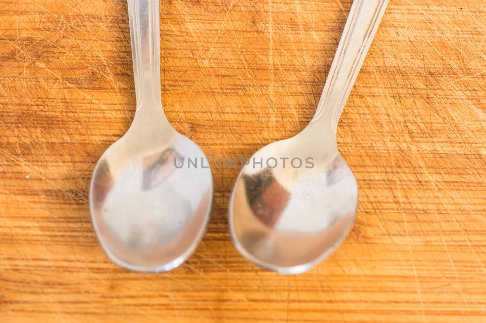 Silver spoons on wooden background