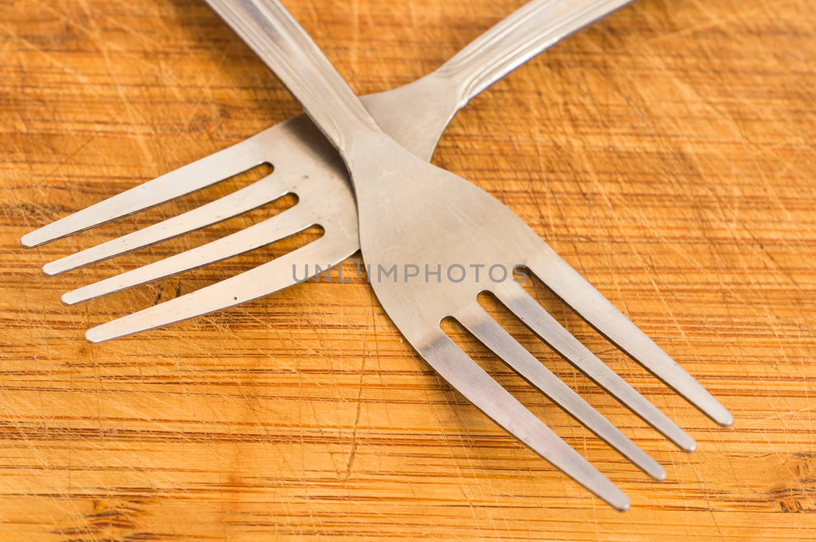 Two silver spoons on wooden background