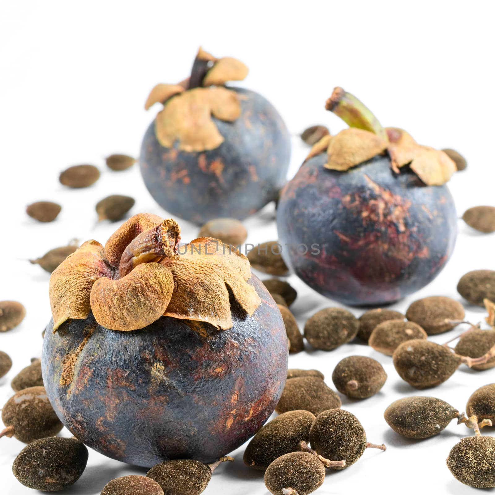 three mangosteen with seeds