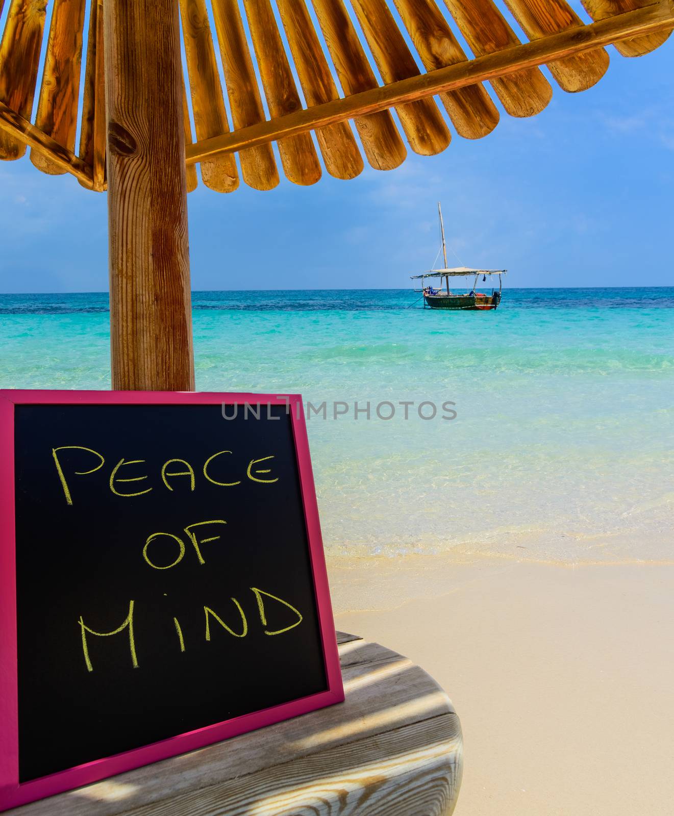 In the picture a Zanzibar beach which is a small blackboard with the words " Peace of mind" in the afternoon .