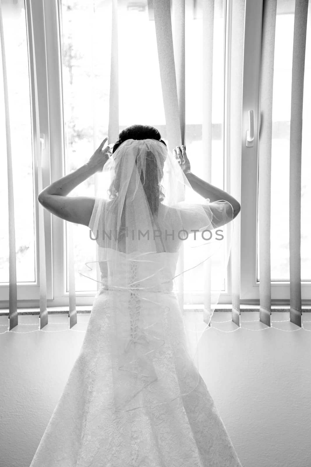 Bride on a window looking for a groom. Wedding concept