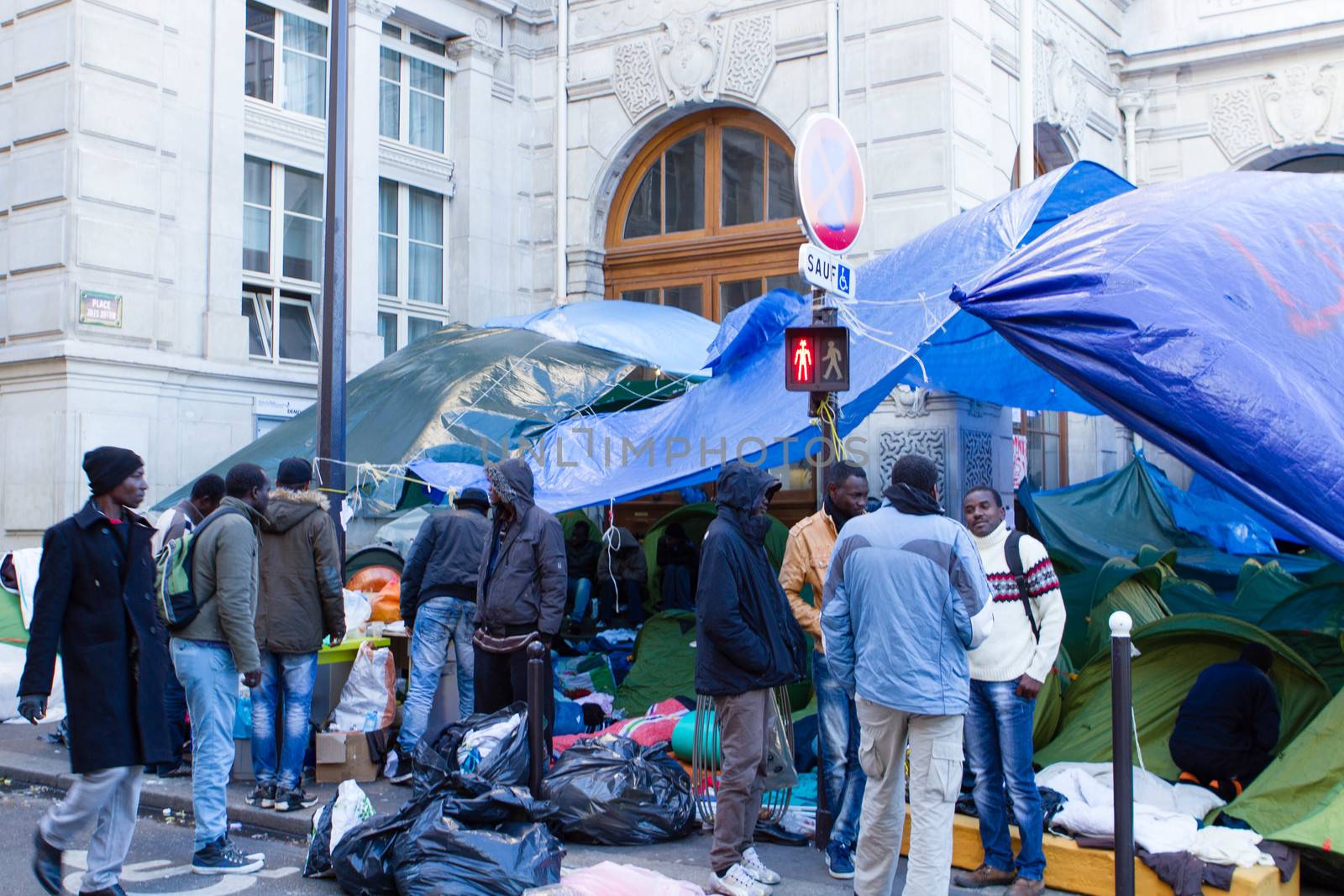 FRANCE, Paris: A dozen of refugees have a conversation in front of the city hall of the 18th arrondissement in Paris, on September, 15, 2015. Almost hundred and fifty refugees from South Soudan and Eritrea camp in front of the city hall of the 18th arrondissement in Paris since September, 4, 2015. Paris mayor Anne Hidalgo announced on September, 15, 2015 giving them a place in one of the seven installations opened in the capital and around las week. 