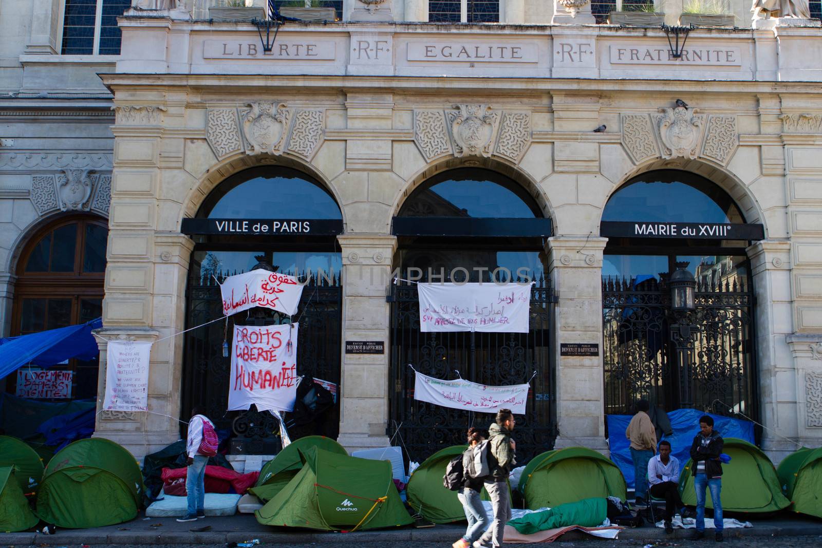 FRANCE, Paris: Several signs claming for liberty and human rights cover the front of the city hall of the 18th arrondissement in Paris, on September, 15, 2015. Almost hundred and fifty refugees from South Soudan and Eritrea camp in front of the city hall of the 18th arrondissement in Paris since September, 4, 2015. Paris mayor Anne Hidalgo announced on September, 15, 2015 giving them a place in one of the seven installations opened in the capital and around las week. 