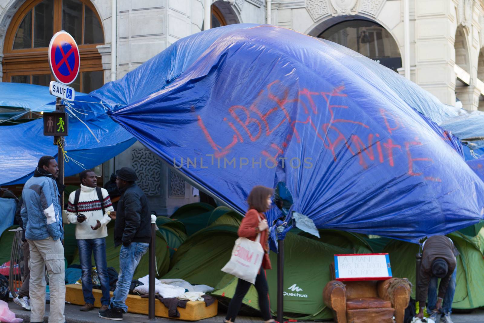 FRANCE, Paris: Three refugees have a conversation in their camp in front of the city hall of the 18th arrondissement in Paris, on September, 15, 2015. Almost hundred and fifty refugees from South Soudan and Eritrea camp in front of the city hall of the 18th arrondissement in Paris since September, 4, 2015. Paris mayor Anne Hidalgo announced on September, 15, 2015 giving them a place in one of the seven installations opened in the capital and around las week. 