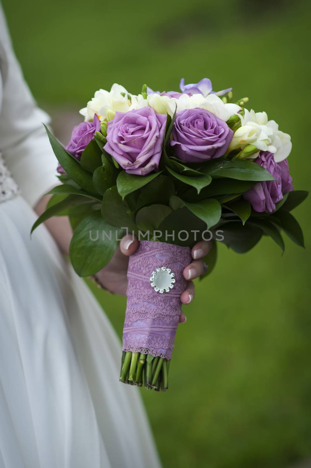 bridal bouquet of purple and white roses in bride's hands